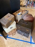 All travel makeup cases grouped on floor in two images showing varying sizes and styles.