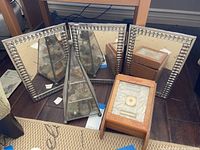 Wide view of 3-fold mirror, pyramid glass display case with perfume bottles, and vintage makeup box on wood floor.