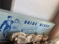 Photo showing Bride Bingo game box and lace-covered bride figurine.