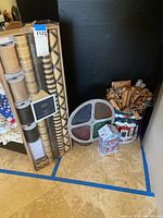 Tall plastic box holding multiple spools of natural and patterned brown twine and ribbon