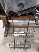 Full view of shower hanging storage shelf showing two metal wire baskets and hook