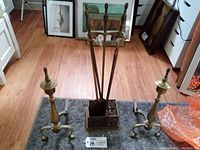 Front and general view of fireplace tools in rack with two brass firedog log holders