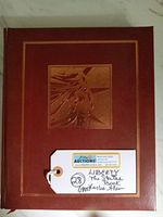 Front cover close-up showing embossed Statue of Liberty image and binding