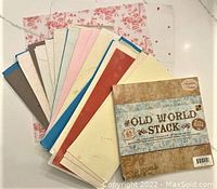 Photo showing assorted sheets of handmade and printed scrapbook paper including Old World Stack scrapbook paper pack.