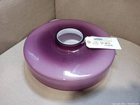 Top-down photo showing the wide flattened shape and white interior center of the purple glass vase.