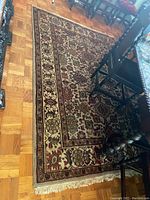 Photo displaying the overall pattern and colors of the oriental area rug with furniture legs partially visible.