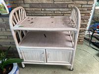 Bentwood stand front view showing two shelves, with some discoloration and wear on the top shelf surface.