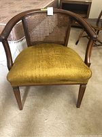 Front view of vintage chair showing cane back and mustard yellow cushioned seat.