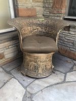 Front and side view of the Hellenic style clay chair showing curved design, cushioned seat, and detailed etchings.