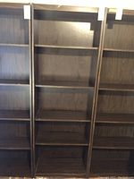 Full view of the shelving unit showing multiple shelves in dark brown wood.