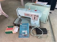 Full view of Singer Style-Mate Model 348 light blue sewing machine with foot pedal, manual, box of attachments, and hard carrying case.