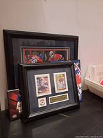Black framed Patrick Roy cards and pin with name plaque, set against backdrop of larger Montreal Canadiens player print.