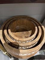 Top view of the three nested wooden bowls showing size gradation and detailed carved decorative band around outer edge