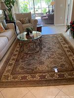 Full view of the 7x9 camel and gold wool area rug in a living room setting showing overall pattern and size.
