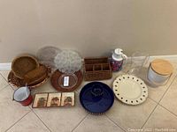 Overview of all serveware and baskets in the lot showing variety of items including chip and dip server, pitchers, baskets, and decor
