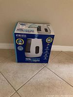 Front view of the boxed Homedics Total Comfort Ultrasonic Humidifier showing product image and branding.