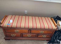 Closed Lane hope chest showing striped padded seat and wooden frame.
