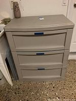 Front view of Suncast utility chest showing two closed drawers and blue pull handles.