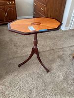 Full view of the octagonal occasional table with wooden inlay and tripod base