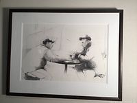 Framed original graphite drawing by Barb Dann showing two men at a table talking over coffee, with visible pencil shading and details.