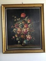 Front view of original vintage framed oil painting depicting a floral still life bouquet in a vase with dark background and multicolored flowers.