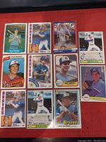Photo of 11 Dale Murphy baseball cards in plastic sleeves arranged on red surface