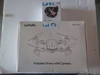 Box of Zuhafa foldable drone with camera and box of Philips smart watch on top