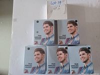 Six boxes of true wireless headset earbuds arranged with three boxes in the top row and three in the bottom row on a plain white surface, each box featuring a man's face wearing an earbud and labeled 'True Wireless Headset'.