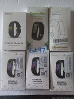 Photo of six fitness tracker boxes from brands Befitrack, OumuEle, Fxant, and unbranded showing packaging and product images.