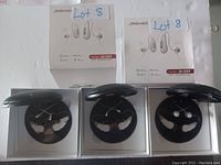 Photo showing three boxes of Jinghao Model JH-D59 Bluetooth wireless earbuds opened with earbuds and charging cases inside each.