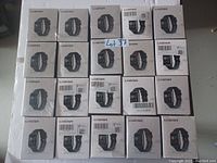 Photo showing 20 boxed L8Star smart watches arranged in four rows of five. Boxes are sealed and display the product image and branding.