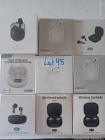 Top-down photo showing all 9 wireless earbud boxes grouped closely together on a flat surface. Brands include P1, S68 Pro, M1, H2, C190, and generic true wireless stereo earbuds.