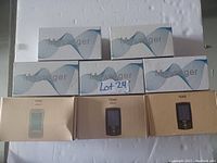 Image shows five white and blue boxes labeled 'Massager' with wave design on top, stacked behind three cardboard boxes labeled 'TENS' with digital device images in light blue, brown, and black colors.