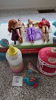 Various dolls including Michael Jackson, Barbie, and a dog toy, shown with bird cage and accessories.