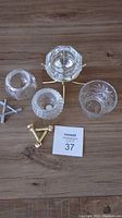 Image showing all four candle holders laid out including baseball, golf, diamond shapes and the round etched holder, along with metal stands.