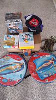 Photo showing all eight items together on carpet including inflatables in bags, boxed inflatables and Coca Cola cooler.