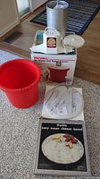 Photo showing the Rival ice cream and yogurt freezer box, red freezer container, freezer components, and the marble Lazy Susan cheese board with its packaging.