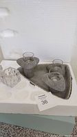 Gray stone triangular tray with three stone candle holders and glass inserts, part of the Living Stones set.