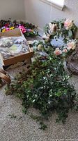 Artificial vines, wreaths and metal baskets on carpet floor