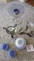Top-down view showing all six items including metal framed and glass tea light holders on carpet.