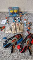 Full lot of two water soakers, figures, birthday pack and wooden games on carpet