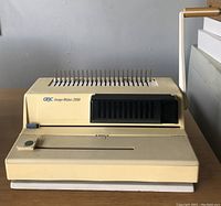 Front view of beige GBC Image Maker 2000 binding machine on table, showing brand and model text and punching pins.