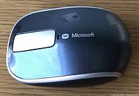 Top view of Microsoft Bluetooth mouse showing brand logo and touch strip