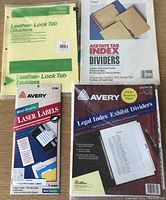 Photo showing four packaged sets of dividers and labels for 3-ring binders: Avery Leather-Look Tab Dividers, Mead 5-Index Acetate Tab Dividers, Avery Legal Index Exhibit Dividers, Avery Mini Sheet Laser Labels.