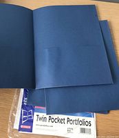 Photo showing interior of folder with two pockets and packaging label indicating 'Twin Pocket Portfolios' by Esselte