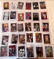 Wide layout of 35 artist trading cards mostly horror themed characters and figures, presented in protective plastic sleeves.