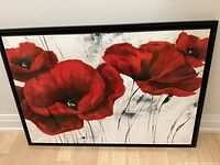Framed canvas art print showing large red poppies on white background.