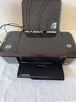 Front and top view of HP Deskjet 3000 printer showing input paper tray and output tray extended.