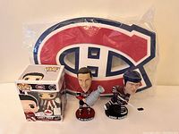 Montreal Canadiens collectibles including Carey Price Funko Pop figure, Jean Beliveau and Andrei Markov bobbleheads, and Canadiens logo foam display.