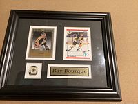 Framed display containing two Ray Bourque hockey cards, a Boston Bruins jersey pin, and engraved name plaque.